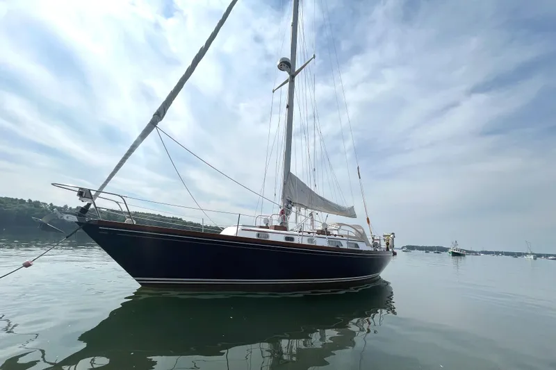 Slide: The Image of 1982 Bristol 38.8 sailboat on calm water under cloudy sky. - 9