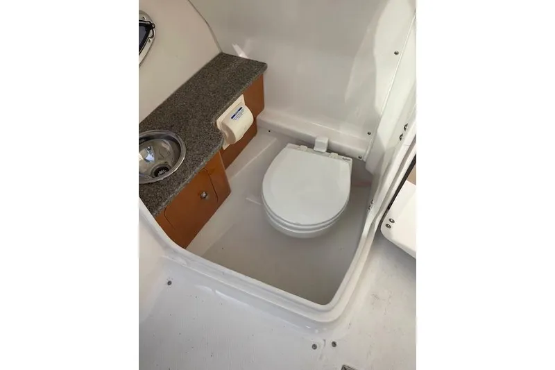 Slide: The Image of 2014 Chaparral 244 Sunesta boat bathroom with sink and toilet. - 5