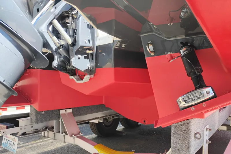 Slide: The Image of 2023 Ranger Tugs R-25 boat stern with red hull and motor components. - 15