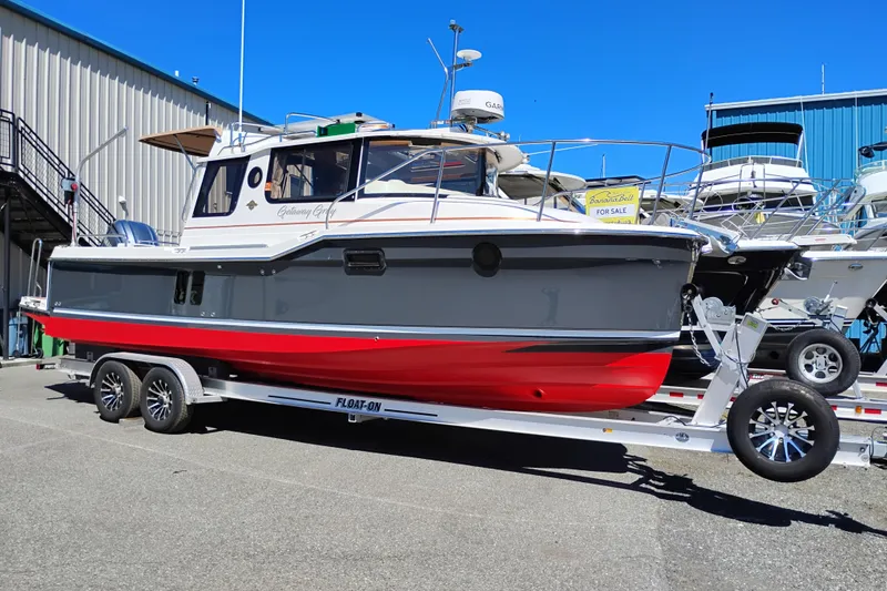 Slide: The Image of 2023 Ranger Tugs R-25 boat on trailer, displayed outdoors for sale. - 2