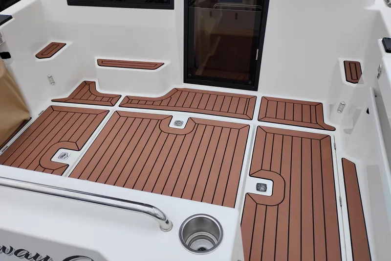 Slide: The Image of 2023 Ranger Tugs R-25 boat deck with teak-style flooring and stainless steel cup holder. - 26