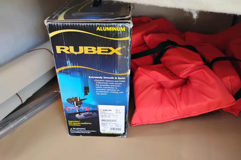 Slide: The Image of Box of Rubex aluminum propeller beside red life jackets on Ranger Tugs R-25, 2023 model. - 30