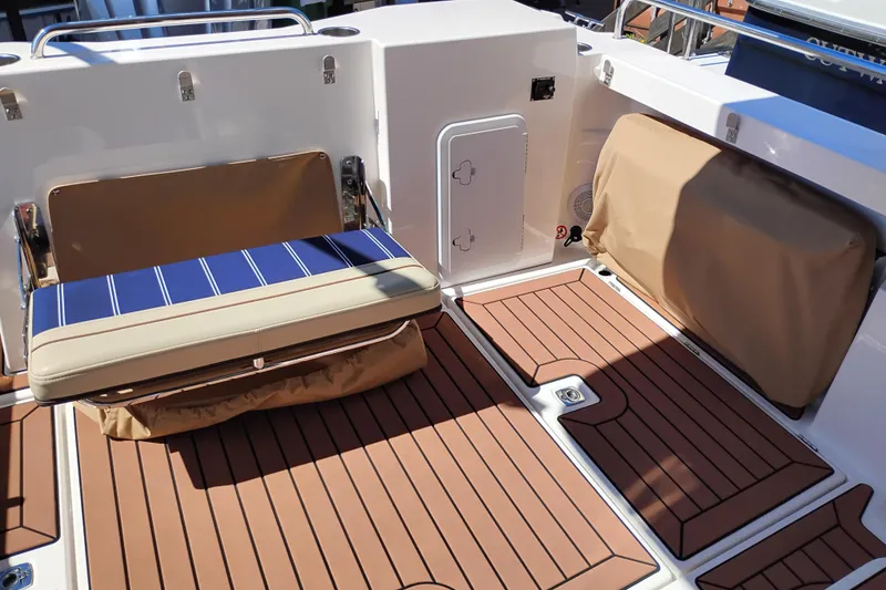 Slide: The Image of 2023 Ranger Tugs R-25 boat deck with cushioned seating and teak flooring. - 31