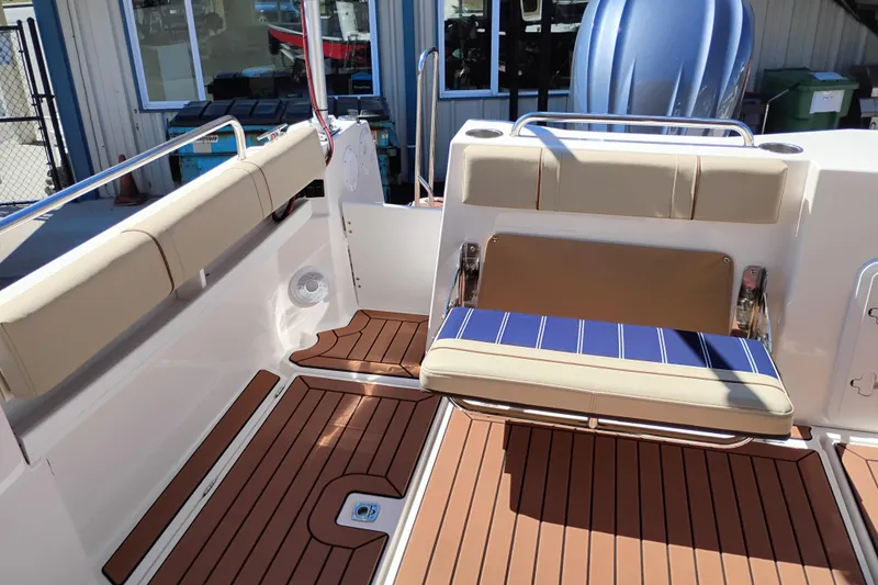 Slide: The Image of 2023 Ranger Tugs R-25 boat interior with cushioned seating and teak flooring. - 32