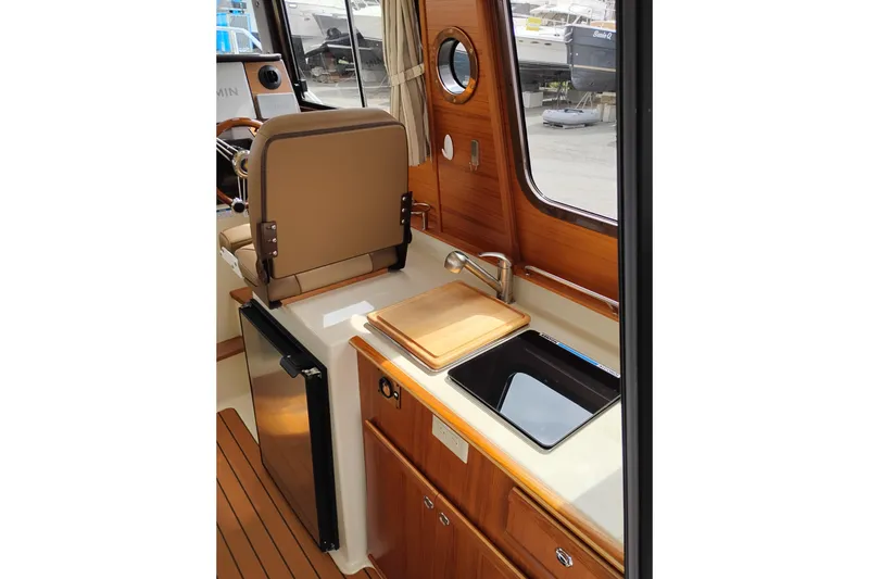 Slide: The Image of Interior of 2023 Ranger Tugs R-25 boat with kitchenette and wooden cabinetry. - 39
