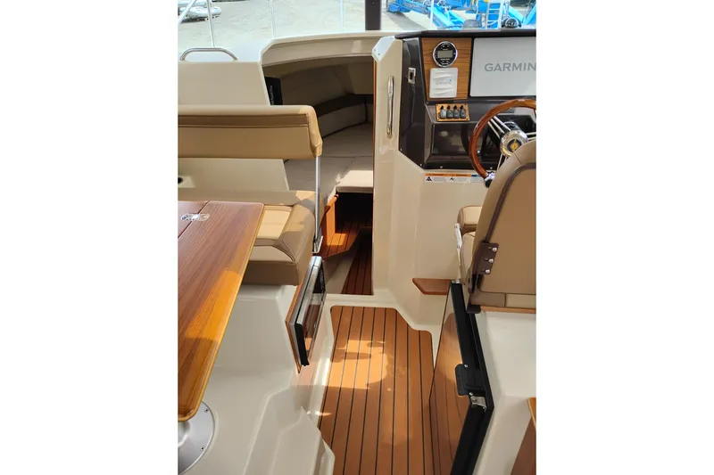 Slide: The Image of 2023 Ranger Tugs R-25 interior with wood flooring and Garmin navigation system. - 40