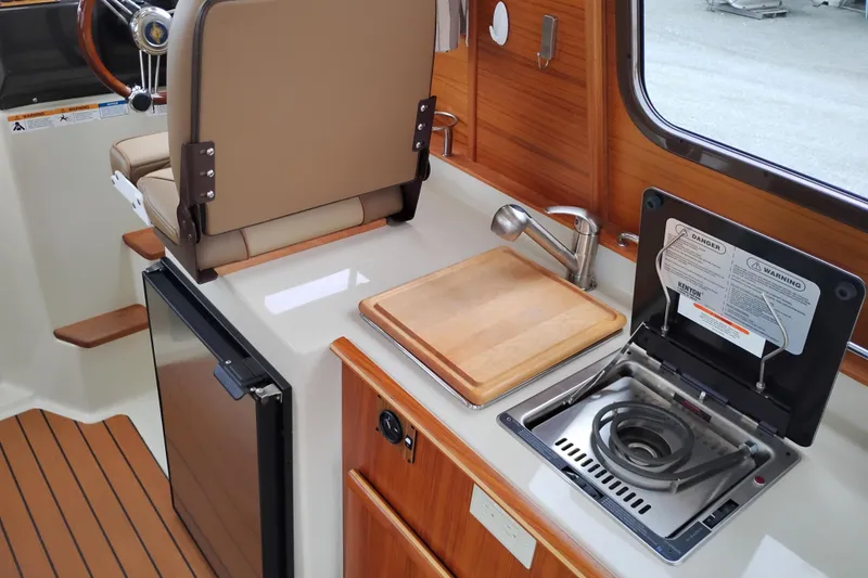 Slide: The Image of Interior of 2023 Ranger Tugs R-25 featuring kitchenette with stove, sink, and cutting board. - 41