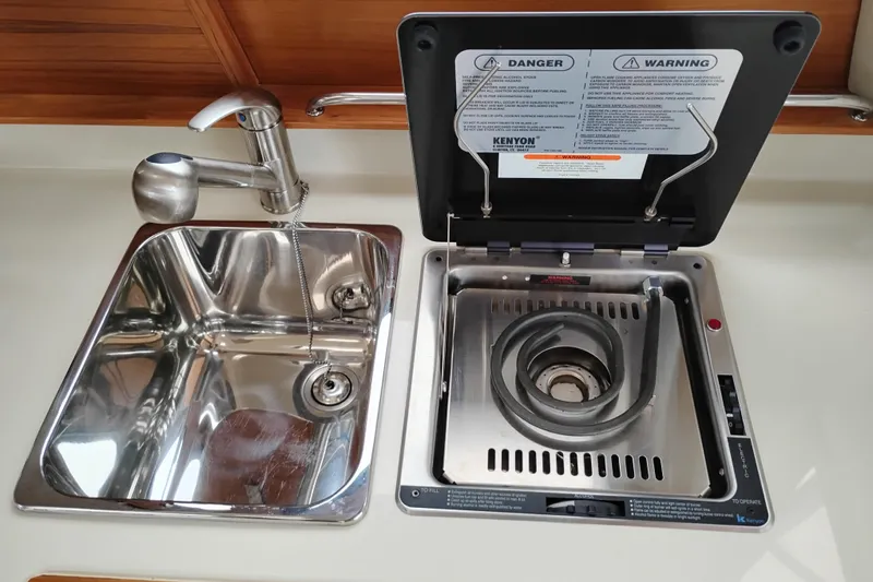 Slide: The Image of 2023 Ranger Tugs R-25 galley with stainless steel sink and Kenyon stove. - 42