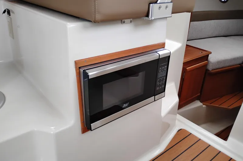 Slide: The Image of 2023 Ranger Tugs R-25 interior with built-in microwave and cozy seating area. - 44