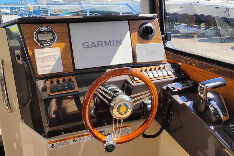 Slide: The Image of 2023 Ranger Tugs R-25 helm with Garmin navigation and Yamaha controls. - 46