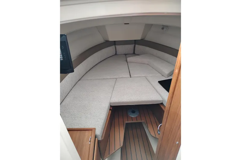 Slide: The Image of 2023 Ranger Tugs R-25 cabin interior with cushioned seating and wooden flooring. - 50