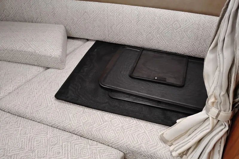 Slide: The Image of 2023 Ranger Tugs R-25 interior with patterned cushions and black trays. - 51