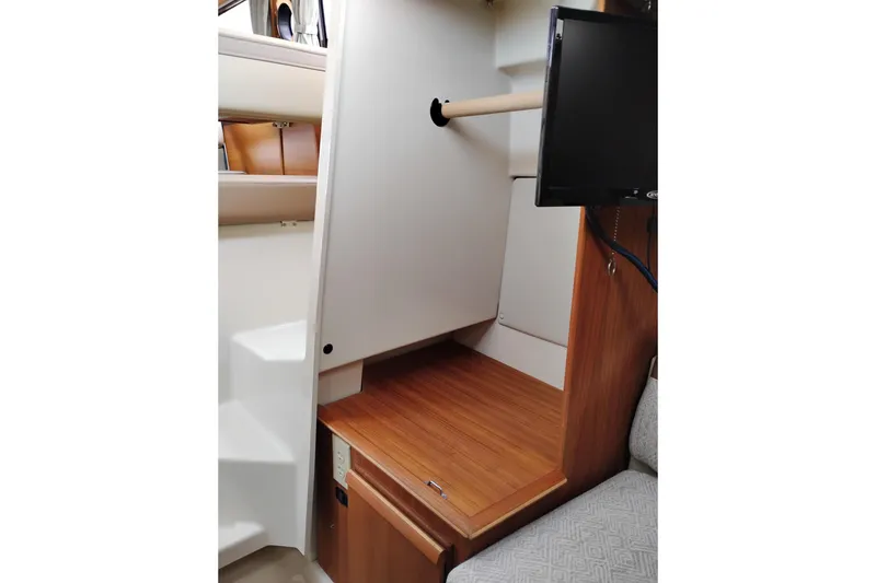 Slide: The Image of 2023 Ranger Tugs R-25 interior with wooden finish, stainless steel sink, and mirror. - 56