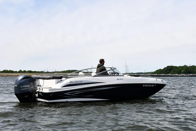 Slide: The Image of 2023 Hurricane SunDeck 217 OB boat on water with Yamaha outboard motor. - 2