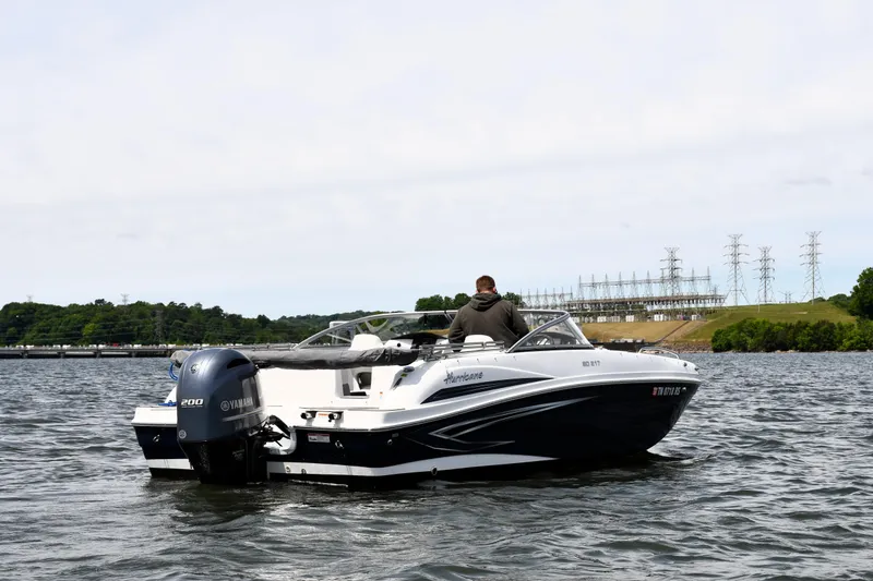 Slide: The Image of 2023 Hurricane SunDeck 217 OB boat on water with Yamaha engine, scenic background. - 3