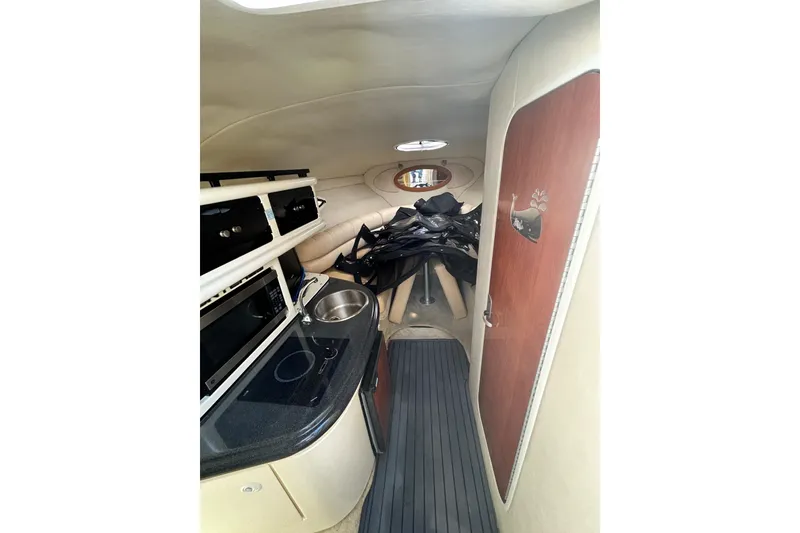 Slide: The Image of Interior of a 2006 Monterey 270 Cruiser boat with kitchenette and seating area. - 11