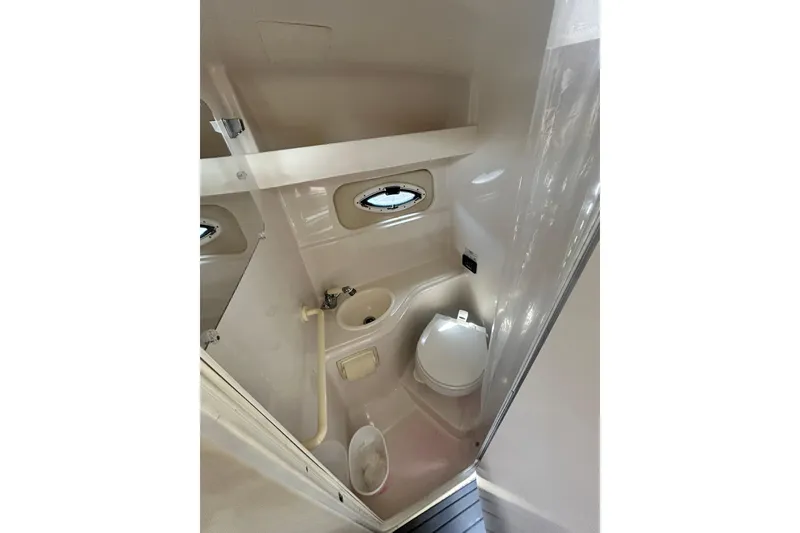 Slide: The Image of 2006 Monterey 270 Cruiser bathroom interior with sink, toilet, and porthole window. - 12