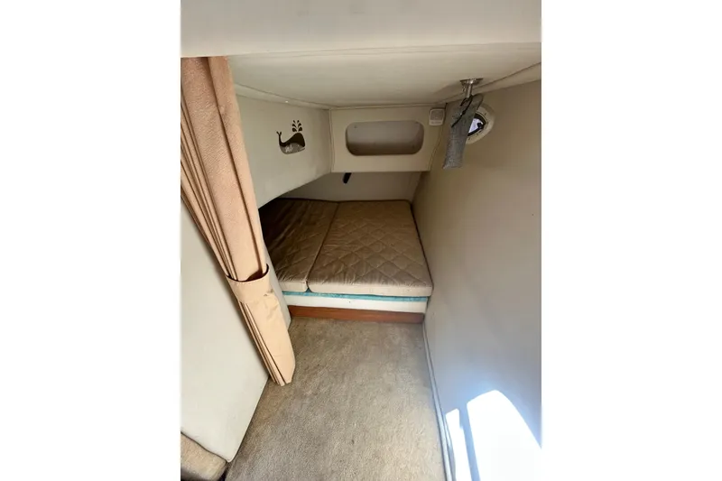 Slide: The Image of 2006 Monterey 270 Cruiser cabin interior with bed, curtain, and wall decor. - 15