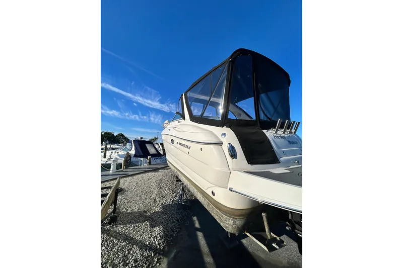 Slide: The Image of 2006 Monterey 270 Cruiser boat on trailer at marina, under a partly cloudy sky. - 25
