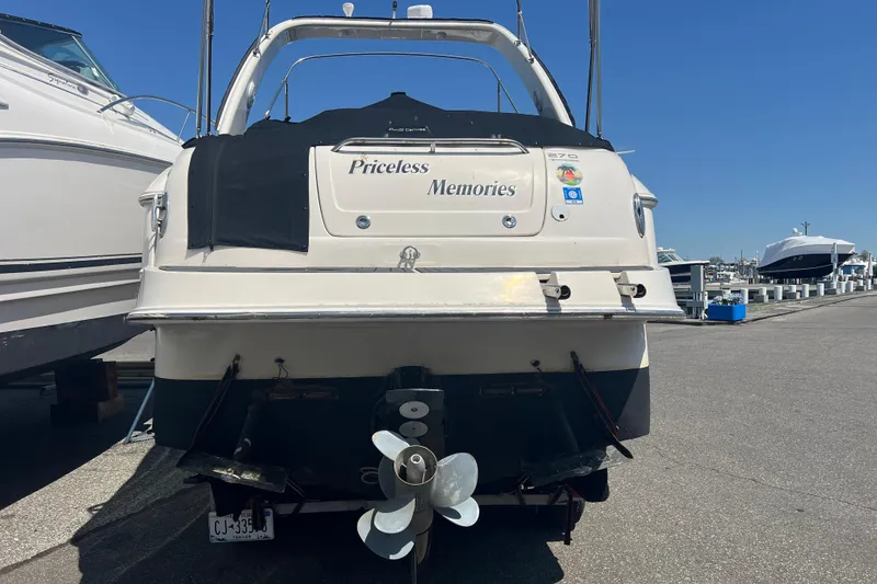Slide: The Image of 2006 Monterey 270 Cruiser boat with black cover, docked in a residential area. - 27