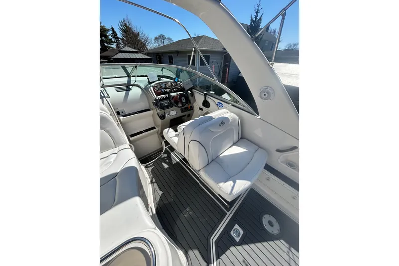 Slide: The Image of Interior of a 2006 Monterey 270 Cruiser boat with white seating and control panel. - 7