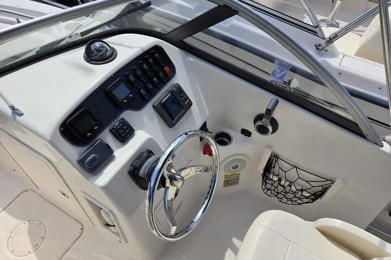 Slide: The Image of 2015 Grady-White Freedom 205 boat dashboard with steering wheel and control panel. - 11