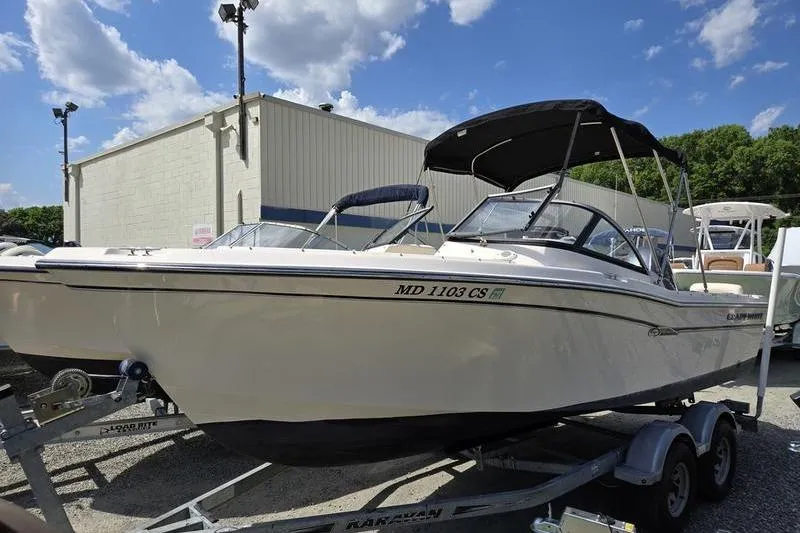 Slide: The Image of 2015 Grady-White Freedom 205 boat on trailer, parked outdoors under a clear sky. - 18