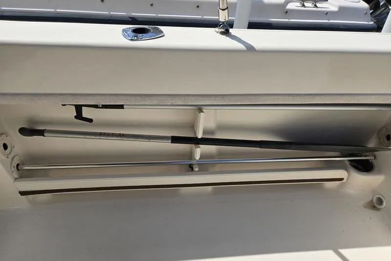 Slide: The Image of Storage compartment in a 2015 Grady-White Freedom 205 boat, featuring fishing rod holders. - 20