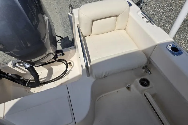 Slide: The Image of 2015 Grady-White Freedom 205 boat interior with cushioned seating and motor detail. - 27