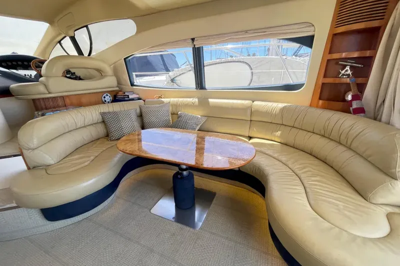 Slide: The Image of Luxurious interior of a 2004 Azimut 46 yacht with beige leather seating and wooden table. - 11