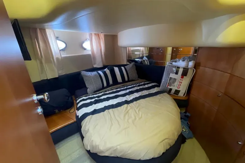 Slide: The Image of Cozy bedroom interior of 2004 Azimut 46 yacht with striped bedding and porthole windows. - 18