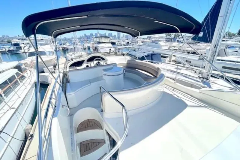 Slide: The Image of Flybridge of 2004 Azimut 46 yacht with seating, helm, and canopy in marina setting. - 30