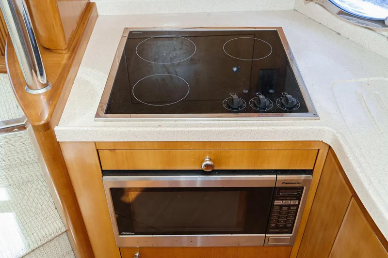 Slide: The Image of Modern kitchen area in a 2004 Azimut 46 yacht with stovetop and microwave. - 56