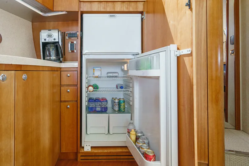 Slide: The Image of Kitchen area of a 2004 Azimut 46 yacht with open fridge and coffee maker. - 57