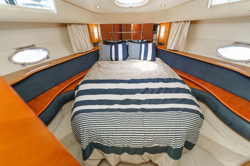 Slide: The Image of Luxurious cabin interior of a 2004 Azimut 46 yacht with striped bedding. - 58