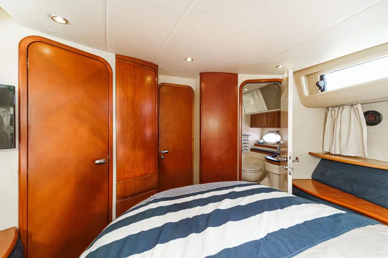 Slide: The Image of Luxurious interior of 2004 Azimut 46 yacht with wood finishes and striped bedding. - 59