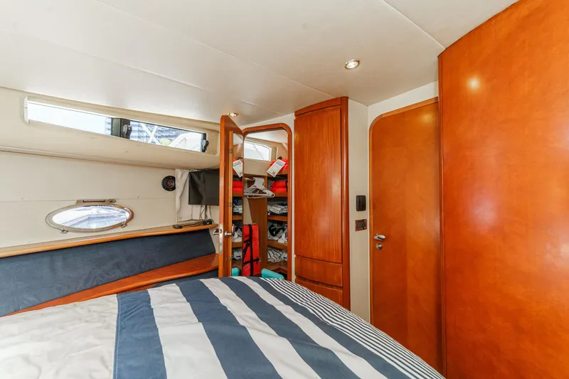 Slide: The Image of Luxurious cabin interior of 2004 Azimut 46 yacht with wood finishes and striped bedding. - 60