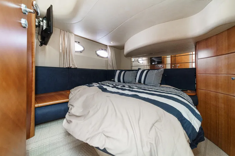 Slide: The Image of Luxurious bedroom interior of 2004 Azimut 46 yacht with striped bedding and wood accents. - 64