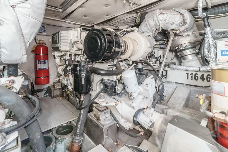 Slide: The Image of Engine room of a 2004 Azimut 46 yacht, featuring mechanical components and a fire extinguisher. - 68