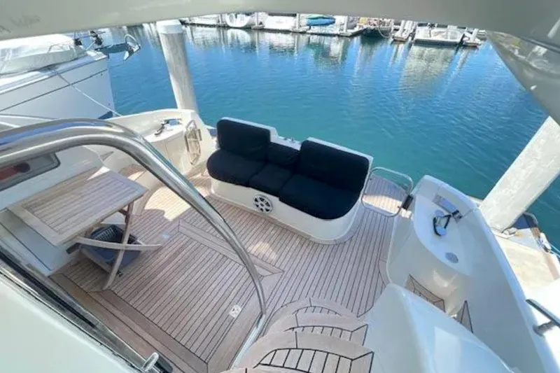 Slide: The Image of 2004 Azimut 46 yacht deck with seating and table, overlooking marina waters. - 9