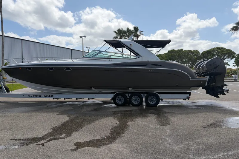 Slide: The Image of 1999 Formula 400 Super Sport boat on trailer, parked outdoors under cloudy sky. - 4