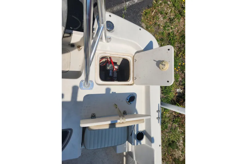 Slide: The Image of 2019 Carolina Skiff 218 DLV boat interior with open storage compartment and visible battery. - 13