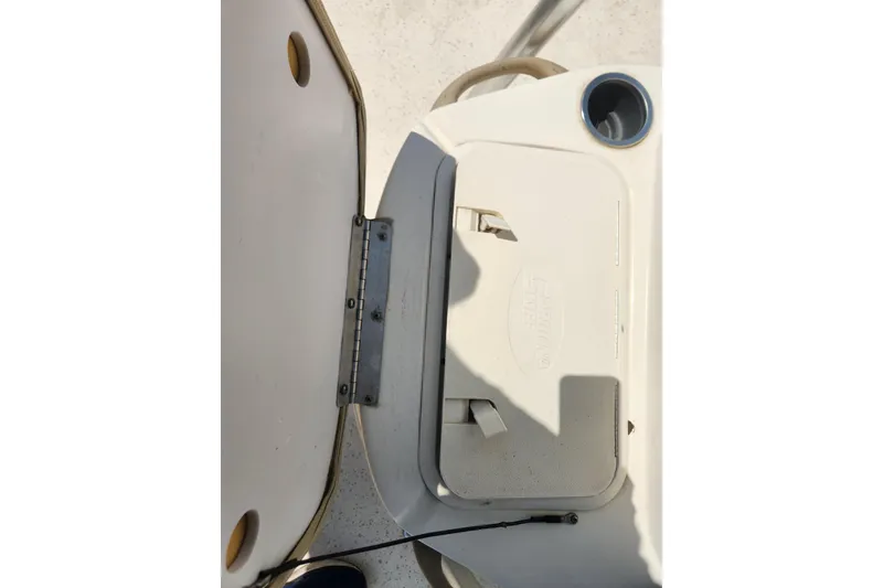Slide: The Image of 2019 Carolina Skiff 218 DLV boat compartment with open hatch and cup holder. - 14