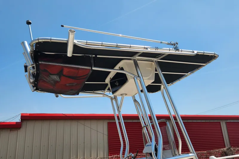 Slide: The Image of 2019 Carolina Skiff 218 DLV boat with T-top and rod holders against blue sky. - 7