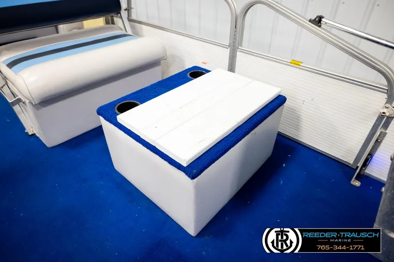 Slide: The Image of Pontoon boat interior with blue carpet, cushioned seating, and a storage box, Hydra 192-23 model. - 24