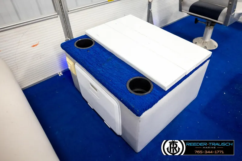 Slide: The Image of Boat interior with blue carpet, featuring a white storage unit and cup holders, Hydra 192-23 model. - 26