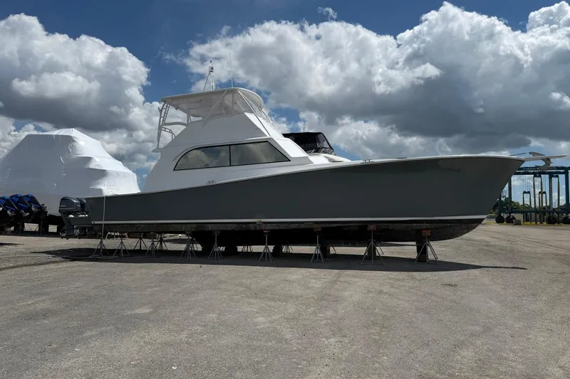 The Image of 1984 Ocean Yachts 55 Super Sport on stands under a cloudy sky. - 0