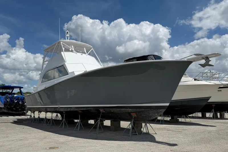Slide: The Image of 1984 Ocean Yachts 55 Super Sport on stands under a cloudy sky. - 2