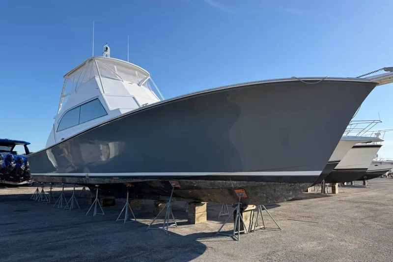 Slide: The Image of 1984 Ocean Yachts 55 Super Sport on stands, side view under clear blue sky. - 3