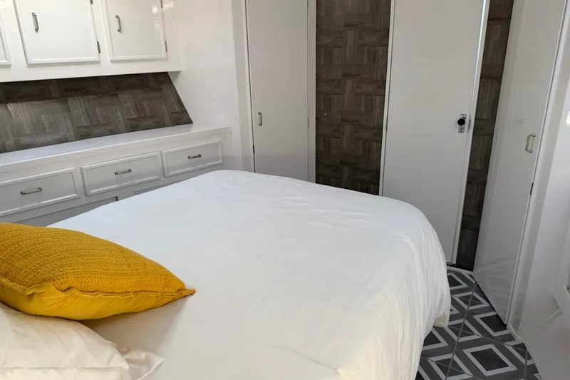 Slide: The Image of Bedroom interior of 1984 Ocean Yachts 55 Super Sport with white decor and yellow pillow. - 31